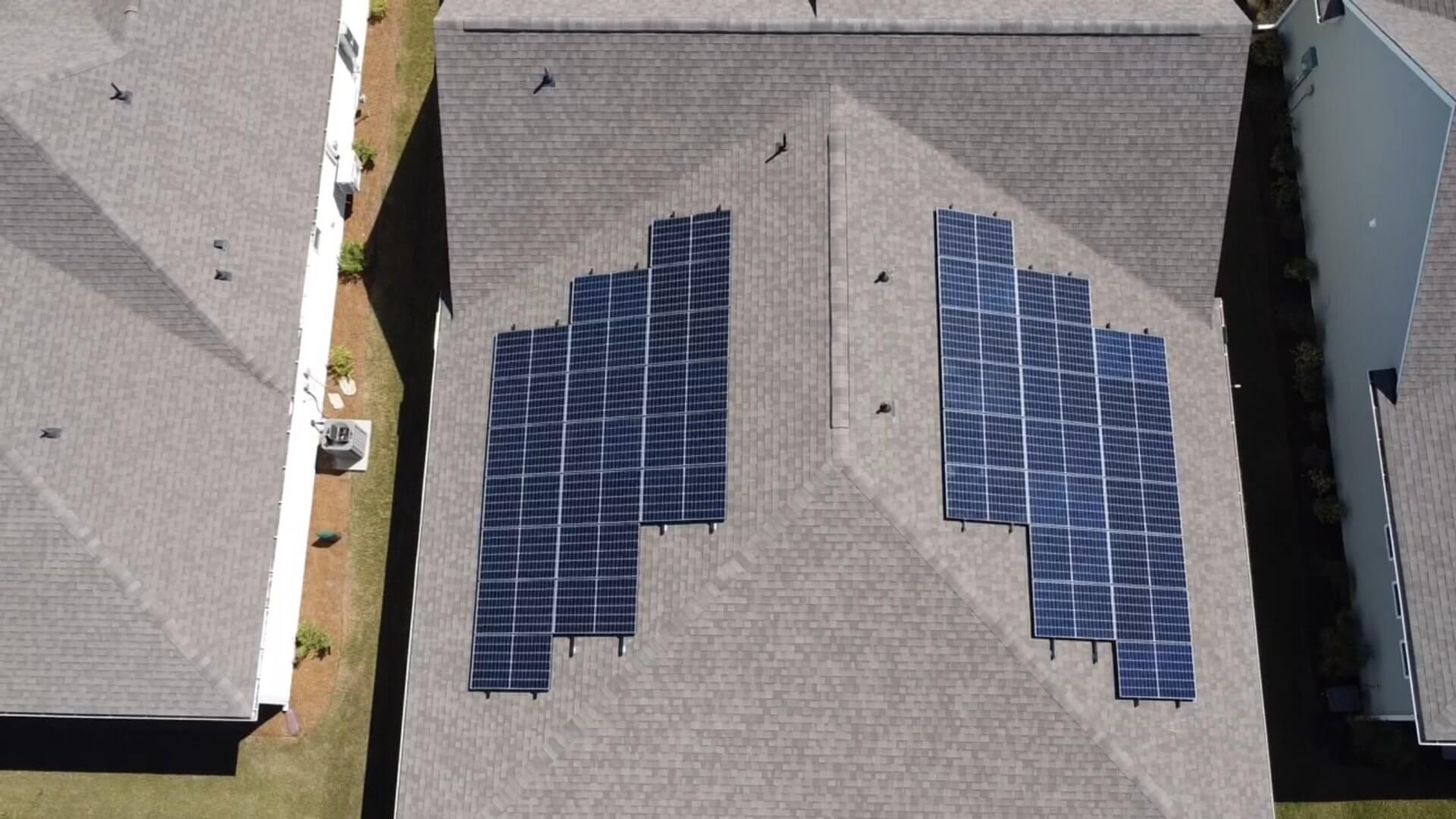 Aerial view of a completed roof-mounted solar installation with two panel arrays