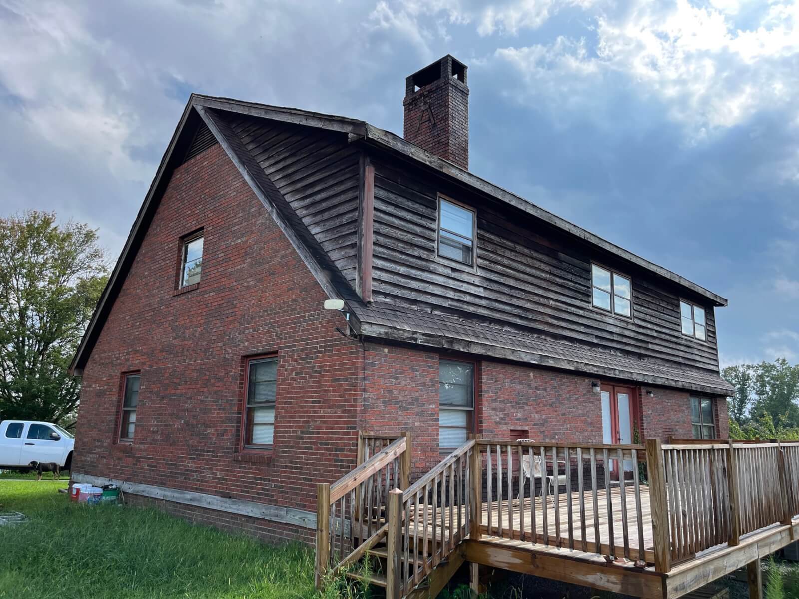 Weathered wood-shake dormer siding and worn roof shingles on an Upstate SC home before replacement