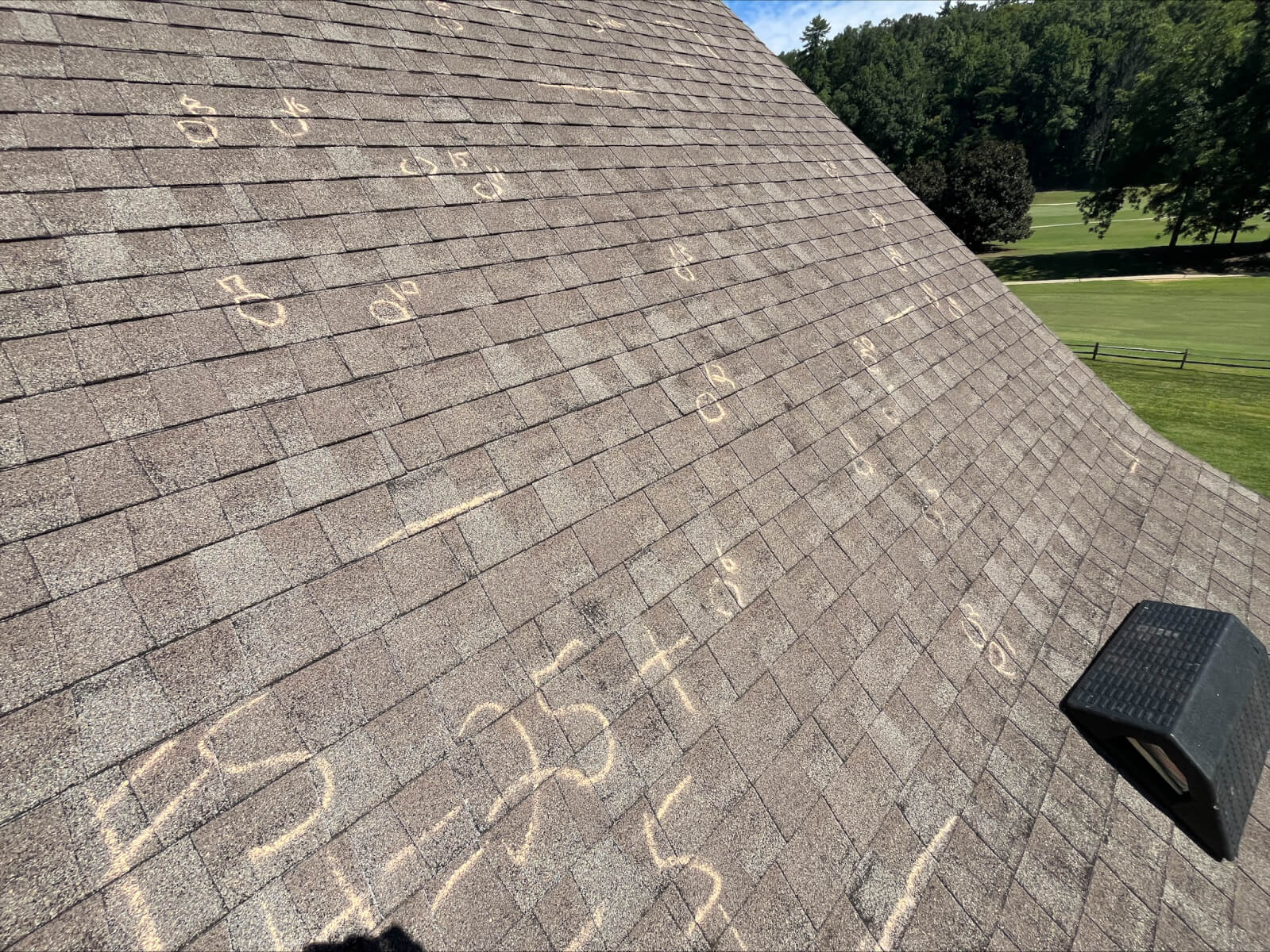 A roof inspection in progress — chalk-circled hail and wind damage marks on asphalt shingles, documented during an Affordable Roofing SC inspection in Upstate SC